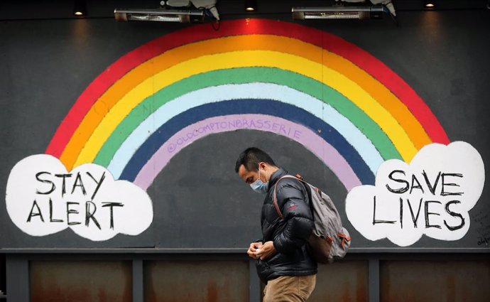 17 February 2021, United Kingdom, London: A man wearing a mask walks past a graffiti with the message "Stay alert, save lives"  in Soho district as the coronavirus lockdown continues in the city. Photo: Tayfun Salci/ZUMA Wire/dpa