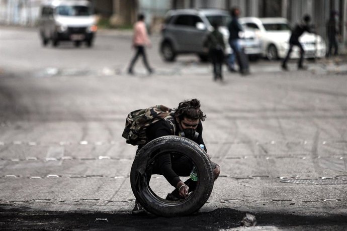 Un manifestante prepara una barricada en Líbano durante las protestas contra el Gobierno por la crisis económica