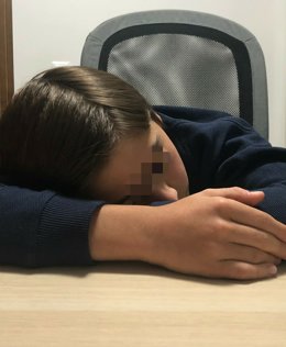 Imagen de un menor descansando sobre la mesa