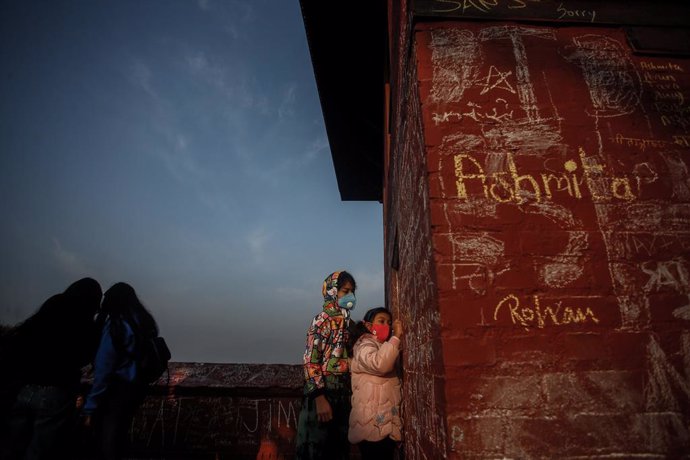 FILED - 16 February 2021, Nepal, Kathmandu: Children write with chalks on the wall of Saraswati temple during Basant Panchami festival, on this day people especially children go to the temple for their first writing and reading lessons in the belief tha