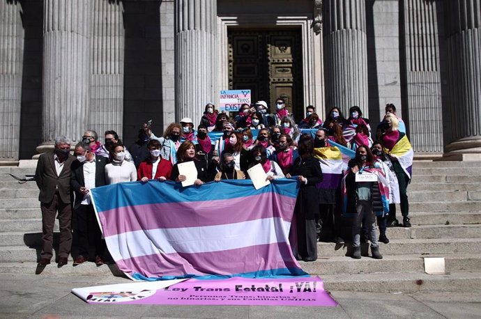 Miembros de colectivos trans posan en una fotografía tras registrar una ley en el Congreso de los Diputados