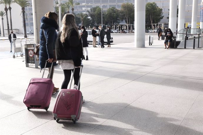 Archivo - Varias personas a las afueras del aeropuerto de Palma de Mallorca (Islas Baleares).