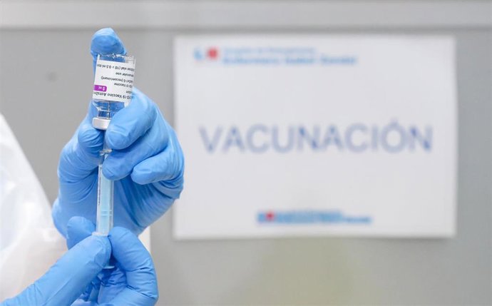Un profesional sanitario sostiene un frasco con la vacuna contra el COVID-19 de AstraZeneca, en el Pabellón 3 del Hospital Público Enfermera Isabel Zendal.