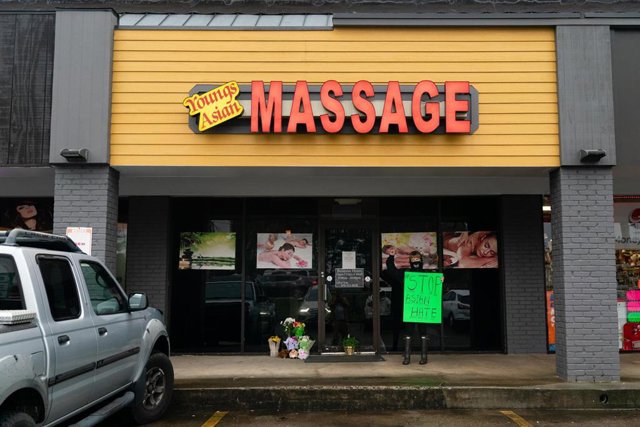 Una mujer sostiene un cartel contra el odio por motivos raciales frente al spa de Acworth, en Georgia, donde murieron cuatro personas en uno de los tiroteos.