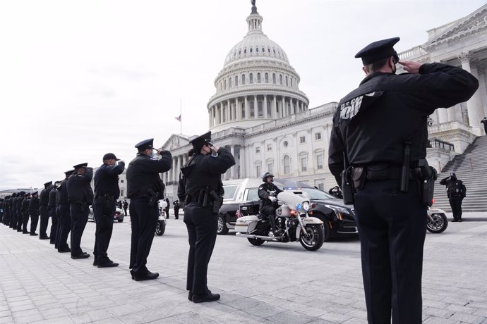Archivo - 03 February 2021, US, Washington: US Police officers salute as the remains of Capitol Police officer Brian Sicknick is brought down after his lying in honor Congressional Tribute at USCapitol Hill. The US Capitol police officer Brian Sicknick