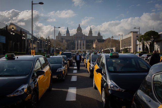Els taxistes protesten a l'avinguda Maria Cristina de Barcelona contra el retorn d'Uber a la ciutat.