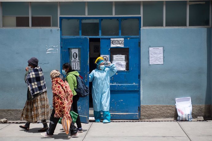 18 February 2021, Bolivia, La Paz: A health worker in a protective suit looks out from the area for receiving Covid-19 patients at Hospital de Clinicas. Doctors announced a strike until 28 February to demonstrate the health emergency health law that res