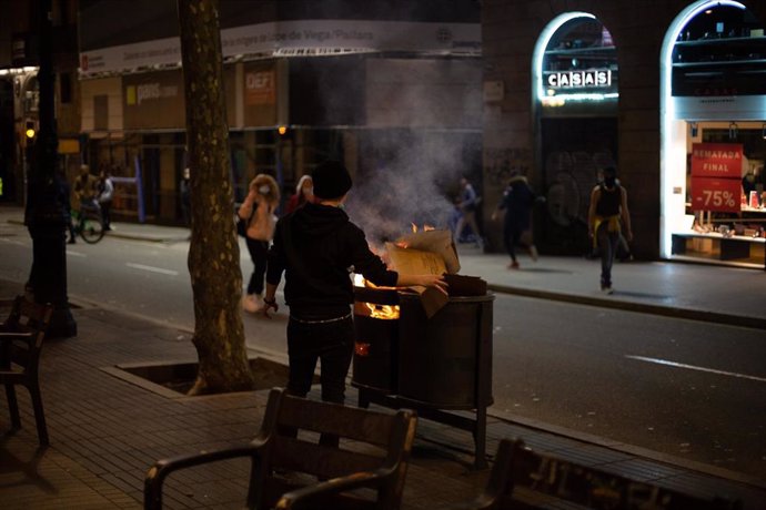 Un activista quema una papelera de La Rambla de Barcelona en los disturbios en apoyo al rapero Pablo Hasel