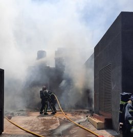 Agentes de bomberos en un incendio en una nave comercial en Añaza