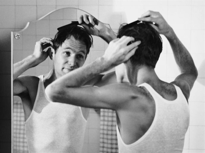 Archivo - Man combing hair in bathroom.  (Photo by George Marks/Retrofile/Getty Images)