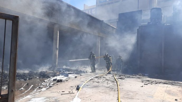 Intervención de los bomberos en el incendio de una nave comercial en Añaza
