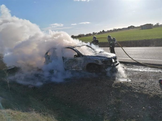 Bomberos de la Diputación de Valladolid apagan el fuego del vehículo afectado.