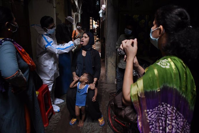 18 March 2021, India, Mumbai: A healthcare worker wearing Personal Protective Equipment (PPE) collects a nasal swab from a woman inside Dharavi slum in Mumbai. Photo: Ashish Vaishnav/SOPA Images via ZUMA Wire/dpa