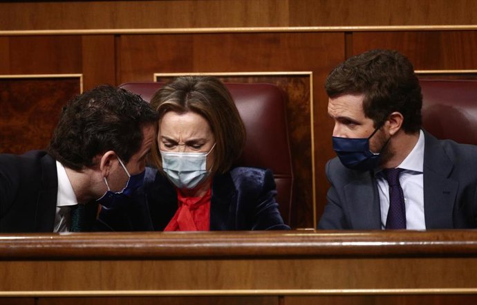 (I-D) El secretario general del Partido Popular, Teodoro García Egea; la portavoz del PP en el Congreso de los Diputados, Cuca Gamarra; y el líder del PP, Pablo Casado, conversan durante una sesión de control al Gobierno en el Congreso