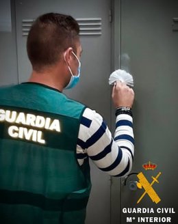 Un agente de la Guardia Civil toma unas huellas en una taquilla