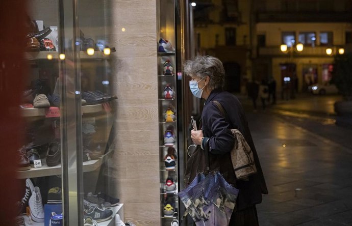 Una persona observa el escaparate de un comercio. Andalucía amplía hasta las 21.30 horas la apertura de hostelería y comercio en municipios con nivel 2 de alerta. En Sevilla (Andalucía, España), a 05 de marzo de 2021.