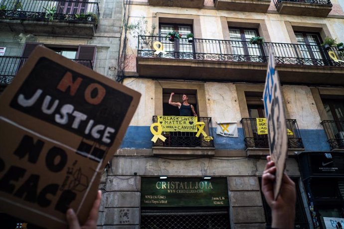 Archivo - Un hombre se asoma a su balcón del que cuelga una pancarta en la que se lee 'Black Lives Matter' en Barcelona