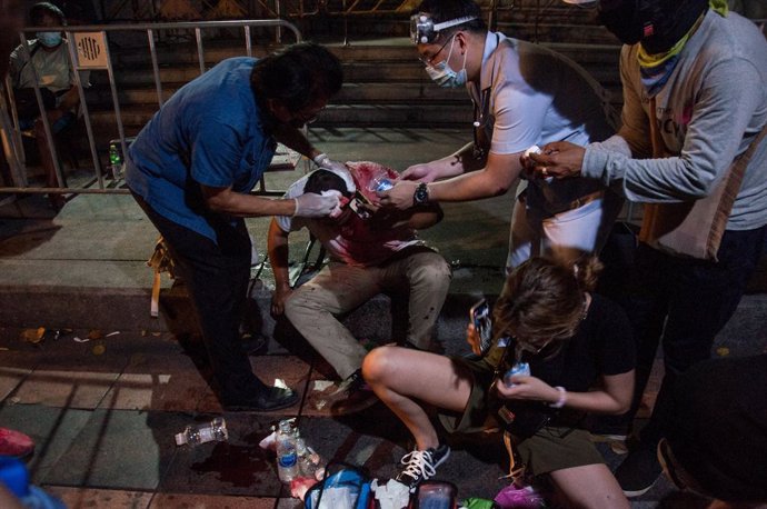 20 March 2021, Thailand, Bangkok: Protesters give first aid to a colleague who was injured during clashes at a pro-democracy protest near the Grand Palace demanding the resignation of Thai Prime Minister Chan-o-cha and reform of the monarchy. Photo: Pee