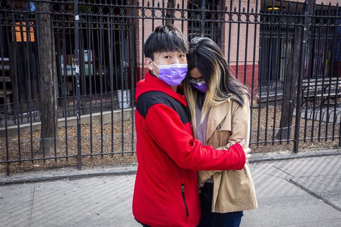 Archivo - March 21, 2020 - New York, New York, United States: A couple wearing masks hugs on East Broadway in Chinatown while the city continues to battle the coronavirus pandemic. (Natan Dvir / Contacto Images)