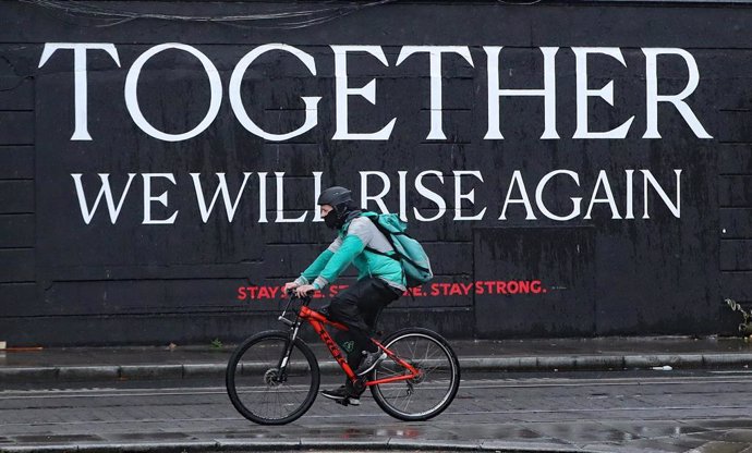 Archivo - Un ciclista pasa ante un mural por el centro de Dublín