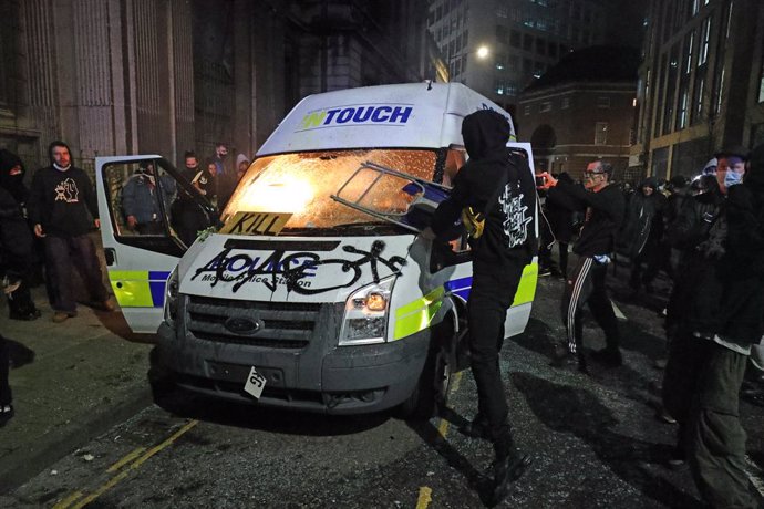 21 March 2021, United Kingdom, Bristol: Protesters set fire to a vandalised police van outside Bridewell Police Station as they take part in a 'Kill the Bill' protest against the Government's controversial Police and Crime Bill. Photo: Andrew Matthews/P