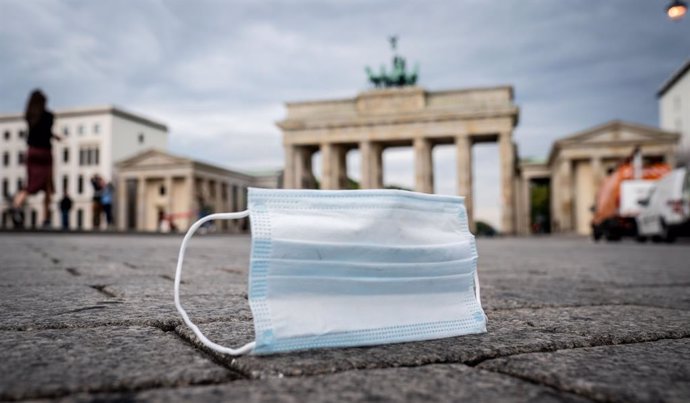 Archivo - 24 September 2020, Berlin: A face mask lies on the ground in front of Brandenburg Gate. German authorities are facing pressure to bring back tougher restrictions to stem the pandemic as the number of new coronavirus cases in the nation jumped 
