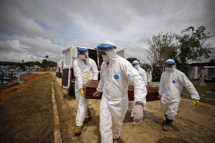 Archivo - 15 January 2021, Brazil, Manaus: Cemetery workers in protective suits carry the coffin of a person who died of Covid-19 at Nossa Senhora Aparecida Cemetery. Photo: Lucas Silva/dpa