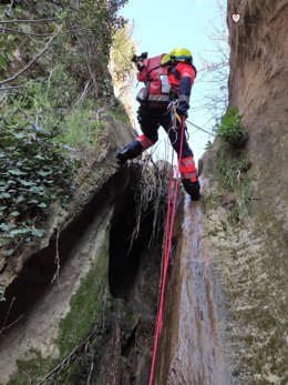 Un efectivo del Consorcio Provincial de Bomberos de Málaga rescata a un perro de una cascada