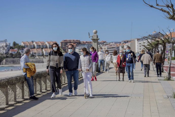 Varias personas caminan por un paseo marítimo en Sanxenxo, Pontevedra, Galicia (España), a 21 de marzo de 2021. El pasado miércoles el Ministerio de Sanidad y las Comunidades Autónomas acordaron una serie de medidas a aplicar durante el puente de San Jo