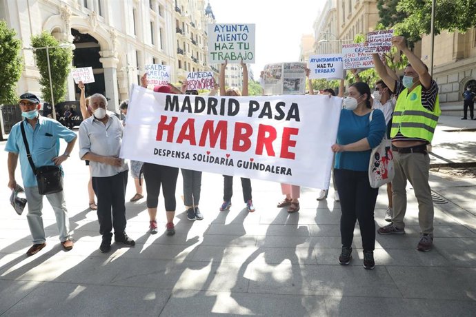 Archivo - Varias personas sostienen una pancarta donde se puede leer "Madrid pasa hambre"
