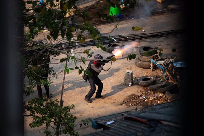 13 March 2021, Myanmar, Yangon: Myanmar police officer shoots towards the demonstrators during a protest against the military coup. Photo: Theint Mon Soe/SOPA Images via ZUMA Wire/dpa