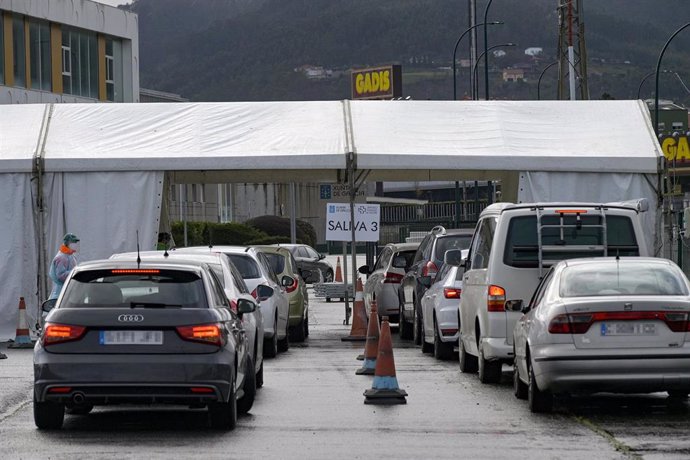 Filas de coches para recoger el test de saliva en la Avenida de Arsenio Iglesias en Arteixo, A Coruña, Galicia, a 24 de enero de 2021. 
