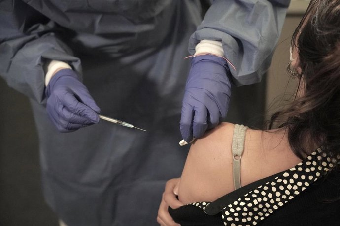 Archivo - Una profesional sanitaria del sector privado recibe la vacuna contra la COVID-19 en un dispositivo instalado en una clínica de Bilbao