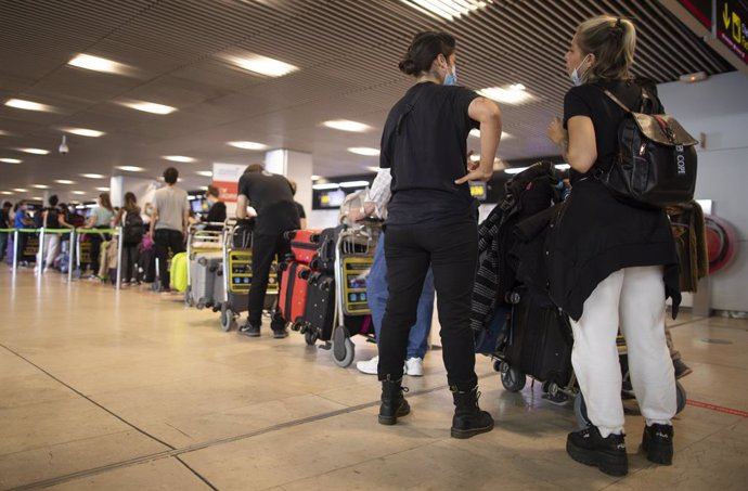 Archivo - Pasajeros con maletas hacen cola para facturar en la Terminal T1 del Aeropuerto Adolfo Suárez Madrid-Barajas el día de su apertura y de las fronteras de España, en Madrid (España), a 1 de julio de 2020. Las compañías aéreas han programado 1.48