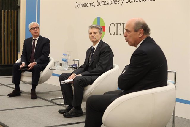 (I-D) Los catedráticos Juan Zornoza; y César García; escuchan la intervención del director General de Tributos, Diego Martín-Abril; en un encuentro Informativo organizado por Europa Press y el CEU sobre impuestos y patrimonio, en Madrid, (España).