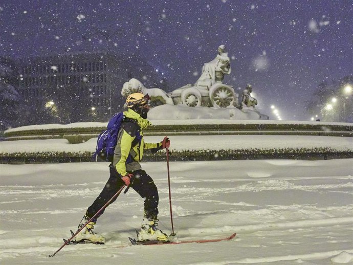 Archivo - Una persona avanza con esquíes junto a la fuente de Cibeles, cubierta de nieve por la borrasca Filomena, en Madrid.