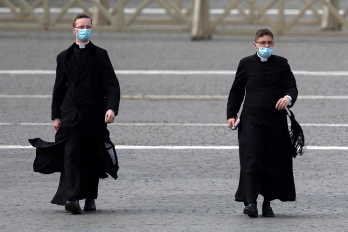 Dos religiosos caminan por la plaza San Pedro en El Vaticano.
