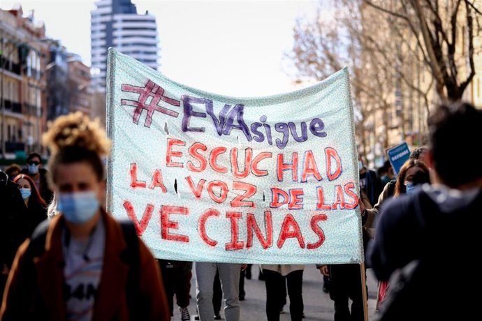 Archivo - Una mujer con una pancarta en la que se lee: `Eva sigue, escuchad la voz de las vecinas 