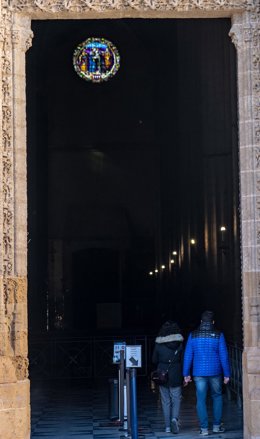 Archivo - Dos personas entran en el interior de la Catedral