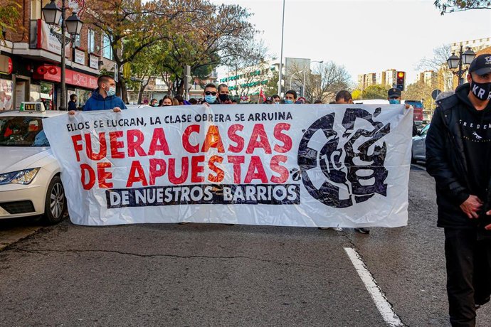 Archivo - Varias personas sostienen una pancarta donde se lee que "Fuera casas de apuestas de nuestros barrios" 