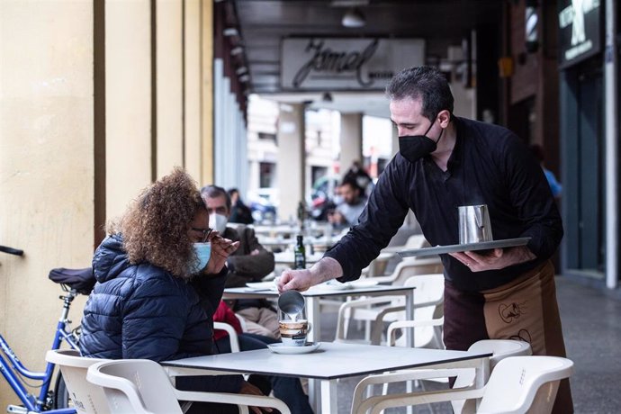 Archivo - Un camarero sirve un café a una clienta en la Cafetería Tristana