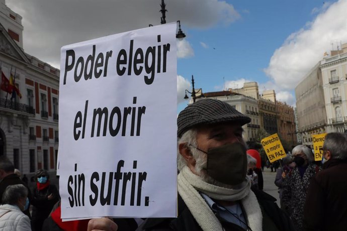 Un hombre con un cartel en el que se lee: `Poder elegir el morir sin sufrir durante una concentración de Derecho a Morir Dignamente en la Puerta del Sol, en Madrid (España), a 18 de marzo de 2021. Derecho a Morir Dignamente se manifiesta para dar apoyo a