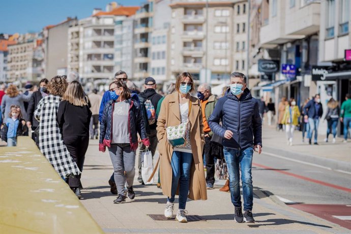 Varias personas pasean por el paseo marítimo de Sanxenxo, Pontevedra, Galicia (España), a 21 de marzo de 2021. El pasado miércoles el Ministerio de Sanidad y las Comunidades Autónomas acordaron una serie de medidas a aplicar durante el puente de San Jos