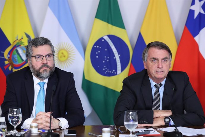 HANDOUT - 16 March 2021, Brazil, Brasilia: Jair Bolsonaro (R), Brazil's president, and Ernesto Araujo, Brazil's Foreign Minister, participate in a videoconference during the 6th extraordinary meeting of the Forum for the Progress and Development of Sout