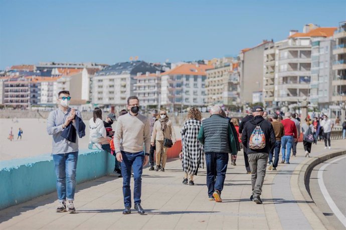 Varias personas pasean por el paseo marítimo de Sanxenxo, Pontevedra, Galicia (España), a 21 de marzo de 2021. 