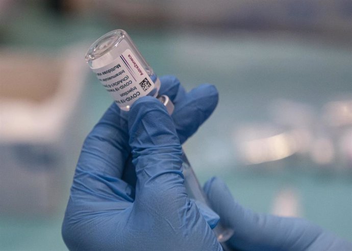 Una profesional sanitaria sostiene una jeringuilla con un vial de la vacuna contra la COVID-19 de AstraZeneca en un dispositivo de vacunación en el pabellón SADUS en Sevilla (Andalucía, España), a 24 de marzo de 2021.