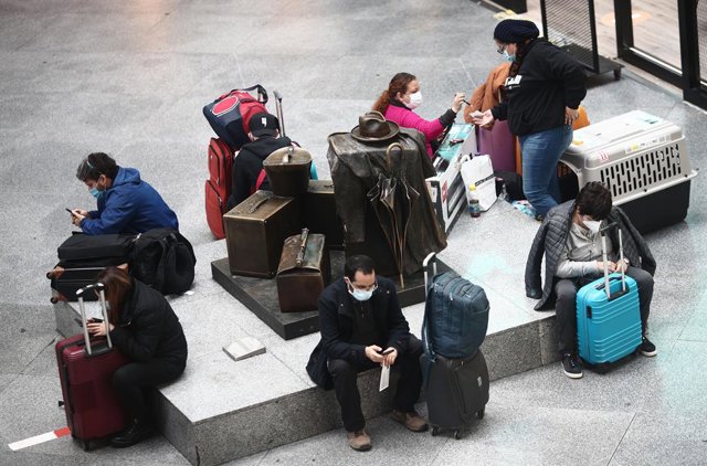 Viajeros esperan en un asiento de la estación de tren de Atocha, a 15 de marzo de 2021. 