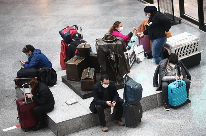 Viajeros esperan en un asiento de la estación de tren de Atocha, a 15 de marzo de 2021. 