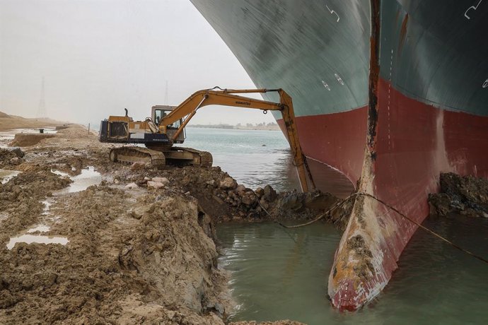 Trabajos de una excavadoras para liberar el buque 'Ever Given', encallado en el canal de Suez