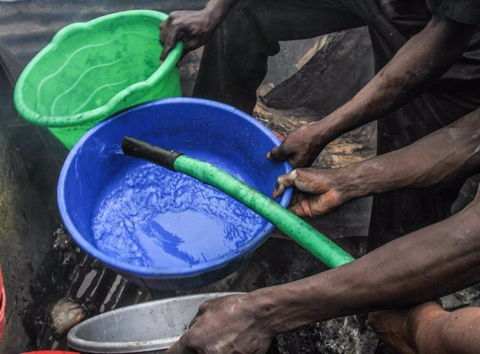 Archivo - La población local trata de apagar las llamas con cubos de agua.